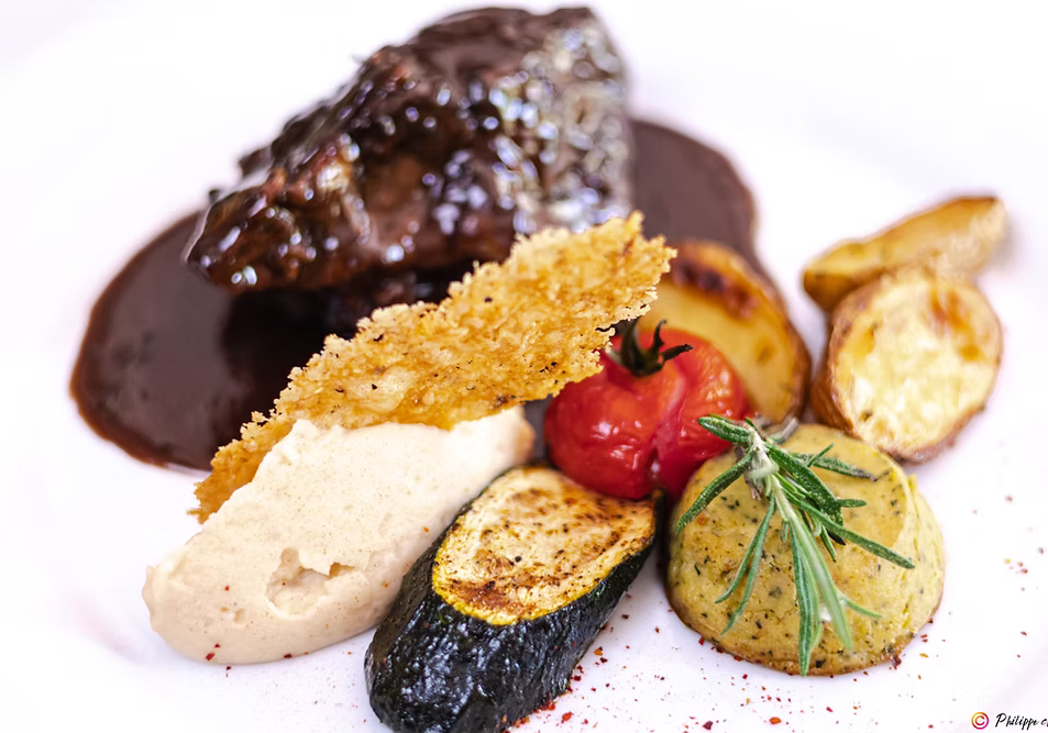 Gourmet vegetable dish at Auberge Amandin, featuring courgettes, aubergines, potatoes and tomatoes, presented with care.