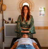 Luma Shiatsu practitioner in Bellegarde conducting a relaxation session, with her hands positioned near the head of a person lying on a treatment table.
