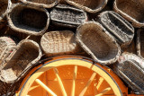 Ensemble de paniers traditionnels en osier de différentes formes et dimensions, disposés autour d'une roue de charrette en bois, illustrant le savoir-faire des vanniers de Vallabrègues.