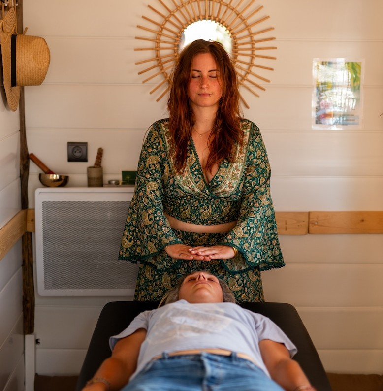 Luma Shiatsu practitioner in Bellegarde conducting a relaxation session, with her hands positioned near the head of a person lying on a treatment table.